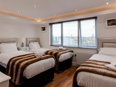Three single beds in a room at Picturehouse Apartments