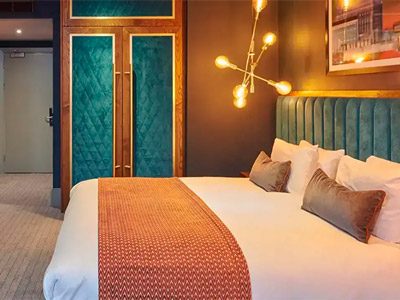 A king bed in a room with warm lighting at Malmaison in Liverpool