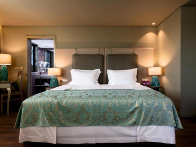 A double bed in a room with warm lighting at Hotel Jaguar Oporto