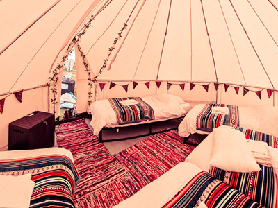 The inside of a luxury yurt with several beds. 
