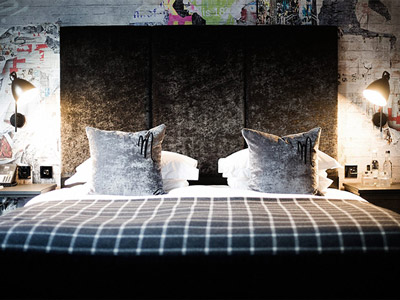 A double bed in a hotel room in the Malmaison with a chequered duvet 