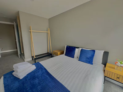 One of the rooms at Monarch Quay with a double bed that has blue cushions 