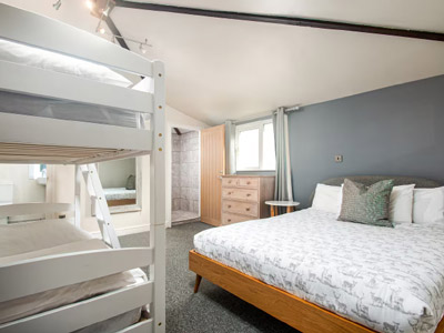 A bedroom at Homeapple Lodge that has a double bed and a bunk bed 