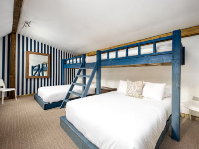 A bedroom at Hudson House that has a bunk bed over two beds 