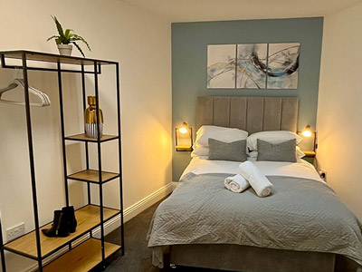 A bedroom at Ben's Place with a double bed and a large piece of wall art 