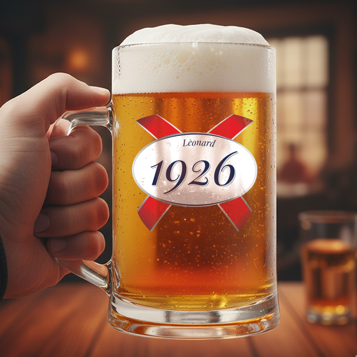 A custom 100th birthday stein with frosted glass and a Kronebourg 1664 design where the 1664 has been swapped for 1926 and has the custom text Leonard on it