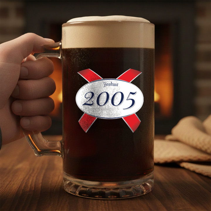 A custom stein with clear glass and a Kronebourg 1664 design where the 1664 has been swapped for 2005 and has the custom text Thomas on it