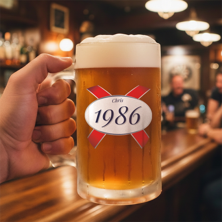 A custom 40th birthday stein with frosted glass and a Kronebourg 1664 design where the 1664 has been swapped for 1986 and has the custom text Chris on it