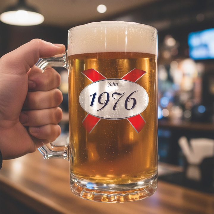 A custom 50th birthday stein with frosted glass and a Kronebourg 1664 design where the 1664 has been swapped for 1976 and has the custom text John on it
