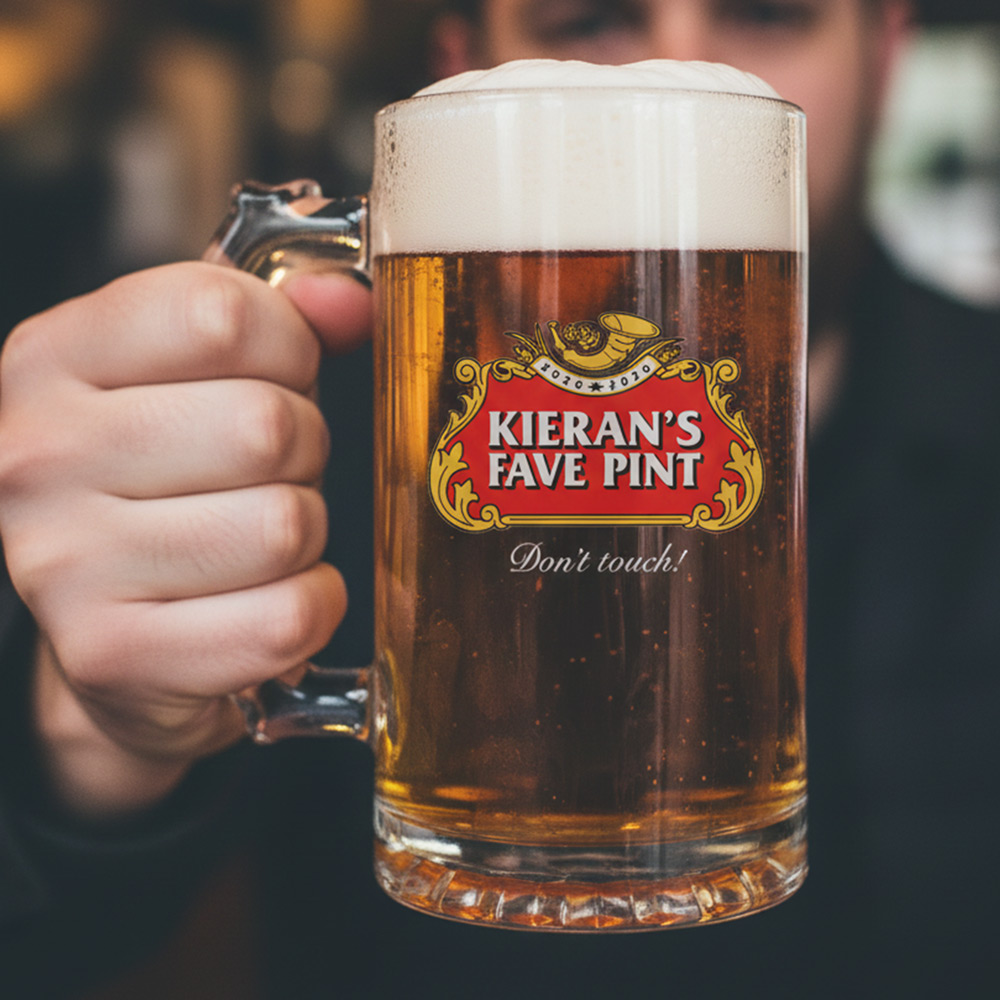 A man holding a custom stella themed stein that has the custom text Kieran's fave pint don't touch!