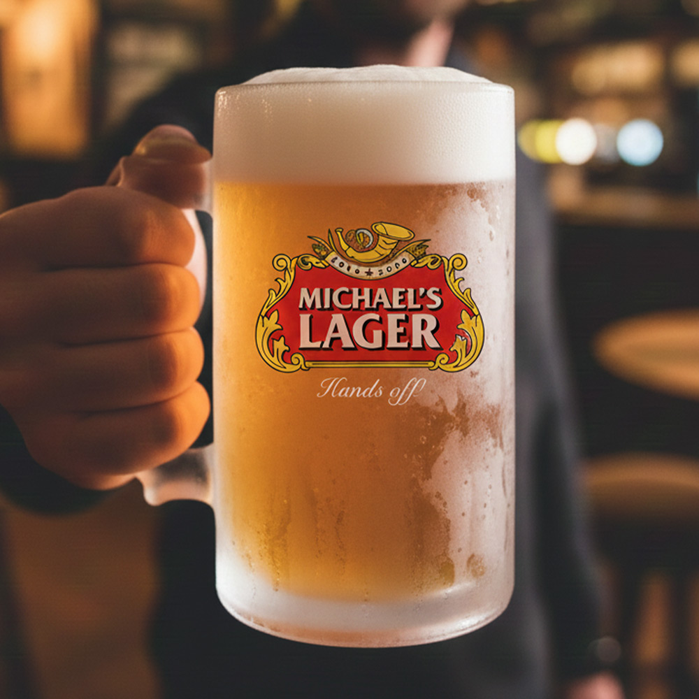 A man holding a custom stella themed stein that has the custom text Michael's Lager Hands off 