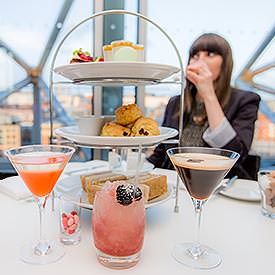 A girl enjoying an indulgent afternoon tea with cocktails in Newcastle's SIX Baltic restaurant