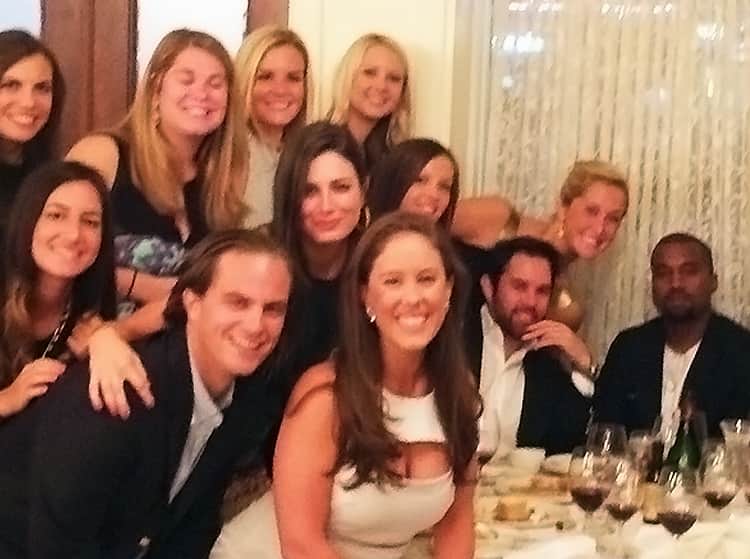 Kanye West posing with a hen party at a restaurant