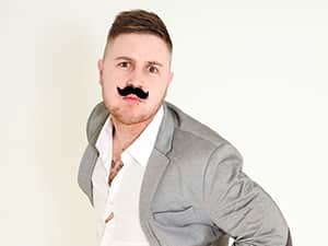 A man posing with a fake moustache on