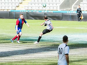 Chris Rawlinson kicking a football at a goalpost at St James' Park