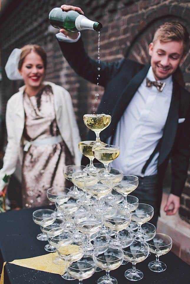 bride and groom pouring champagne into a champagne fountain