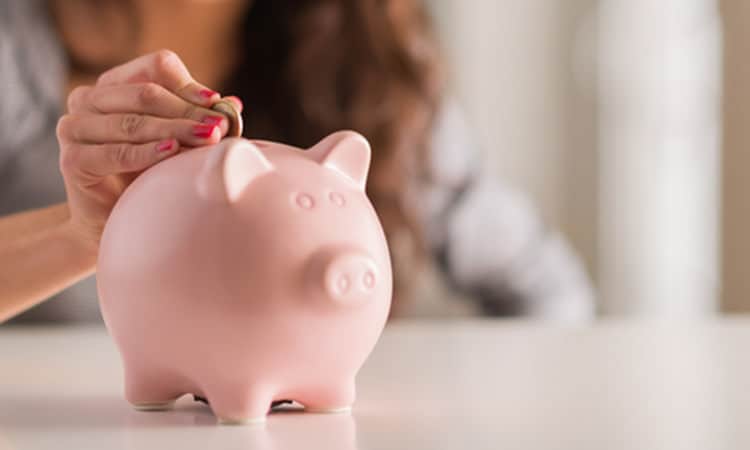 Woman putting money into a piggybank