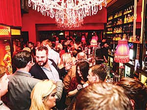 A group of people queuing for a bar in a busy club 