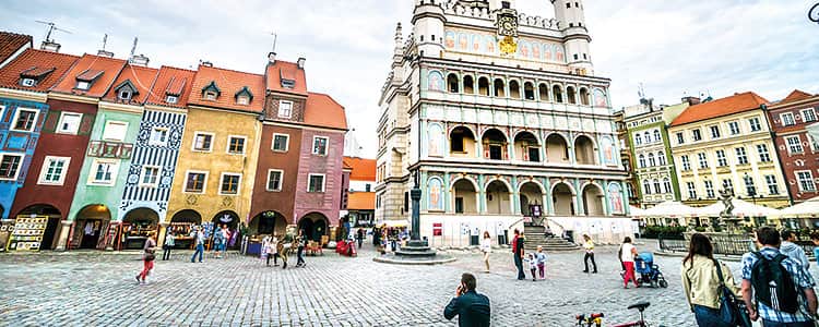 The Renaissance Town Hall in Poznan and the colourful buildings in the Old Town centre, with people in the foreground