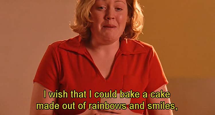 A scene from the film Mean Girls, with a blonde woman in a red T-shirt crying