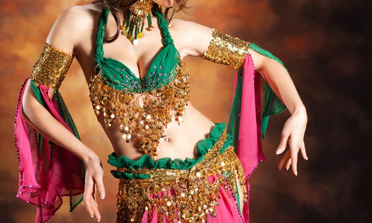 A close up of a woman's torso wearing a green and gold sari 