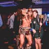 A man dressed as Conan the Barbarian, stood with a woman holding his axe