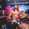 A man dressed as Conan the Barbarian, with two women in the background
