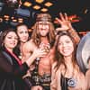 A man dressed as Conan the Barbarian and posing with three women