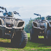 Some quad bikes lined up on a grassy hill