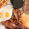 The All In breakfast at Longhorns, including: bacon, eggs, potatos, pancakes, sausages, beans, black pudding, waffle and maple syrup