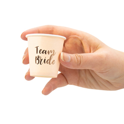 Hand holding Rose Gold Team Bride Shot Glass isolated on a white background