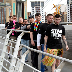 Stag-ipede multi person t-shirt, 8 guys wearing stitched together t-shirt on the Millennium bridge, Newcastle
