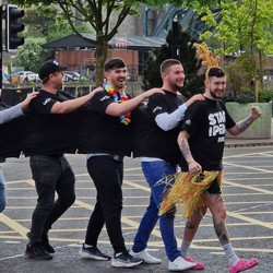 Stag-ipede multi person t-shirt, 8 guys wearing stitched together t-shirt crossing the road in Newcastle
