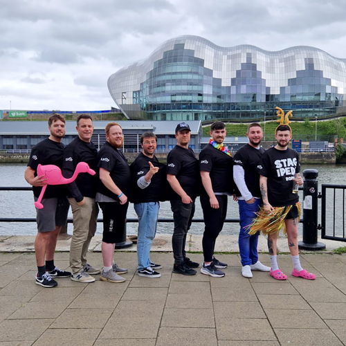 Stag-ipede multi person t-shirt, 8 guys wearing stitched together t-shirt in front of the Sage, Newcastle