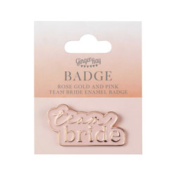 A pastel pink enamel badge with Team Bride written in rose gold on pink packaging.