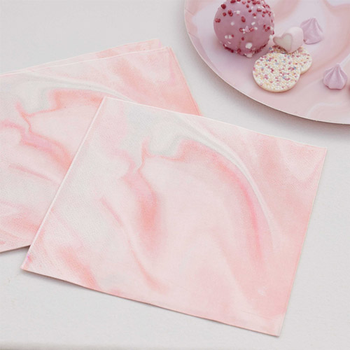 Pink marble napkins set up on a table at a party.