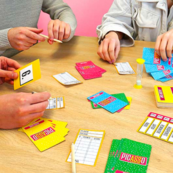 Group of friends around a table playing Picasso drawing and guessing game.