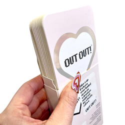 Hand holding open Out Out card box isolated on a white background.