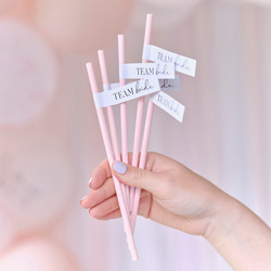 Someone holding a bunch of paper straws with a team bride tag on them
