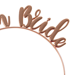Close up of rose gold team bride headband on a white background