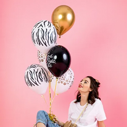 A woman holding Girls Night Out Party Balloons in a pink room