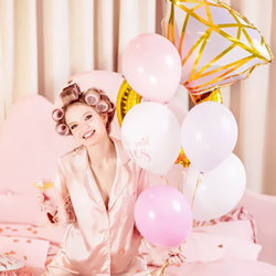Woman holding She Said Yes Balloon Set on a pink bed