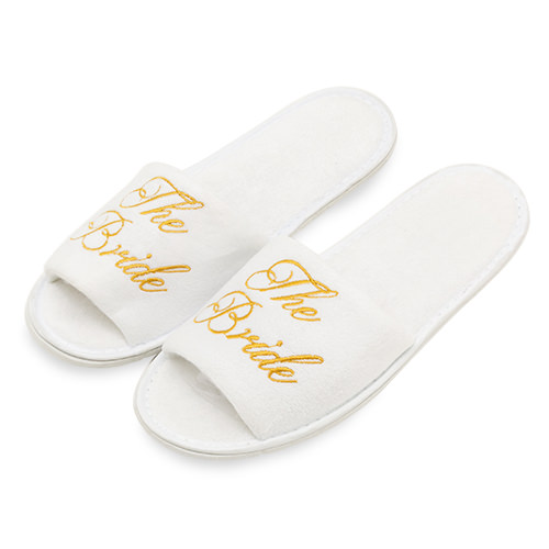 The bride slippers in white with gold writing.