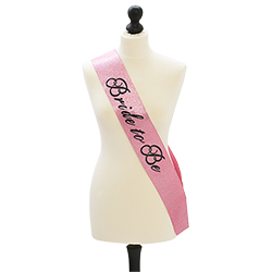 A pink and glittery bride to be sash on a mannequin