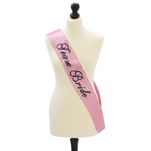 A pink glittery sash with Team Bride written on, modelled on a mannequin