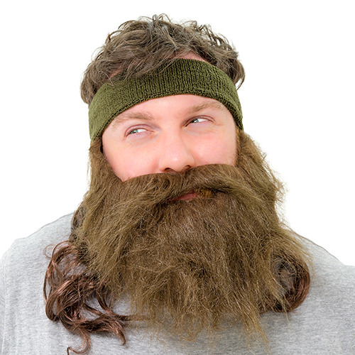 A man looking angry wearing a fake beard and mullet attached to a headband 