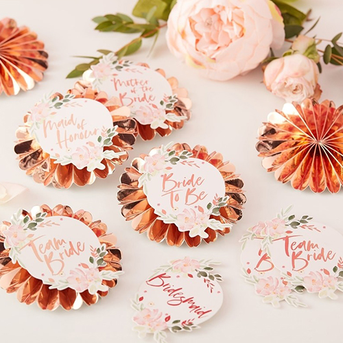 A selection of the floral team bride badges on a table.