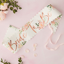 The floral sash on a pink table.