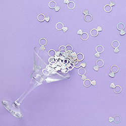 Diamond ring confetti on purple background.