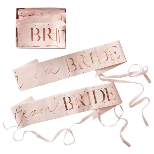 Pink team bride sashes seen on a white background.